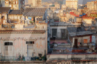 A man comes out of his rooftop home in the early morning light in Havana, Cuba, West Indies, Caribbean, Central America