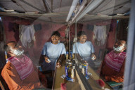 A hairdresser smiles for the camera in his little barbershop in Rishikesh, Uttaranchal, India, Asia