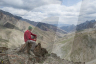A trekker stops to admire the views from the top of the Konze La in the remote Himalayan region of Ladakh in northern India, India, Asia