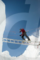 A climber makes his way across a crevasse using a temporary ladder, Khumbu region, Himalayas, Nepal, Asia
