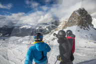 Skiers look out at the Dolomites while skiing at Campitello di Fassa in Italy