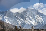 A trekker on his way to Everest base camp in Nepal. Everest is the distant peak on the left and Lhotse is the peak on the right.