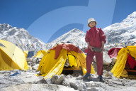 A woman stands by her tent shortly fter climbing Everest