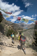 Prayer flags mark a high point in the trail where trekkers are rewarded with their first glimpse of Phoksundo lake in Nepal
