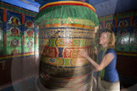 A trekker spins a prayer wheel while trekking towards to Everest Base Camp in Nepal