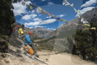 Prayer flags mark a high point in the trail where trekkers are rewarded with their first glimpse of Phoksundo lake in Nepal