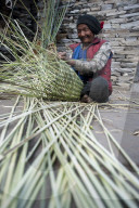 A man uses great skill and traditional knowledge to make a bamboo basket (Doko) by hand in Nepal