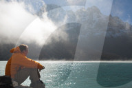 A trekker in the Everest region looks out over Gokyo lake