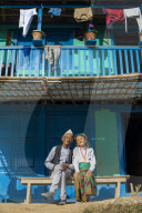 A old Nepali couple wearing traditional dress sit outside their house in Diktel, Khotang District, Nepal, Asia
