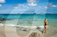 A woman in a bikini walks along a beach on Koh Tao, Thailand.