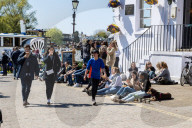 Members of the public enjoy the sunshine in London.