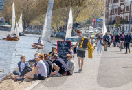 Members of the public enjoy the sunshine in London.