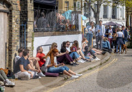 Members of the public enjoy the sunshine in London.