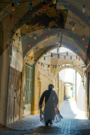 Mullah hurrying down typical vaulted alleyway, Yazd, Iran