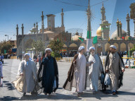 Chatting mullahs against the minarets of the Hazrat-e Masumeh (Holy Shrine), Qom, Iran