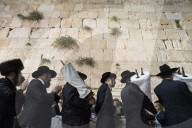 Orthodox Jews dancing with Torah scrolls during Simhat Torah festival. Western Wall. Jerusalem Old City. Israel.