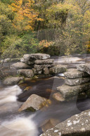 Remains of an ancient clapper bridge at Dartmeet, Dartmoor National Park, Devon, England. Autumn (October) 2015.