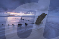 Shipwreck of the Helvetia on Rhossili Beach, looking towards Worm‚Äôs Head at sunset, Rhossili, Gower, Wales. Winter (January) 2016.