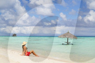 Woman sitting on beach, Fakarava, Tuamotu Islands, French Polynesia (MR)