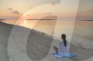Woman practicing yoga at sunrise, Rasdhoo Island, Northern Ari Atoll, Maldives (MR)