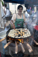 Woman frying tiny chickpea and quails egg fritters on a street market food stall in Pyin Oo Lwyn, Mandalay Division, Myanmar.