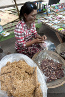 Woman selling delicious home made fresh peanut brittle and vermicelli brittle in Kalaw market, Shan state, Myanmar.
