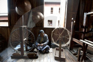 Woman spinning silk thread on a spinning wheel with bicycle wheel, Ko Than hlaing Weaving,  Inpawkhan, Inle Lake, Shan state.