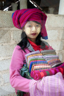 Young girl with thanaka paste on her face, selling scarves and sarongs at Nyaung Oak Monastery, Indein, Inle Lake, Shan state.