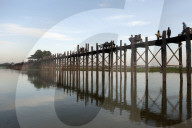 People crossing U Bein's Bridge, supported by 984 teak posts over 1.2 km distance across Thaumthaman Lake, Mandalay.