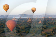 Hot air balloons flying over the terracotta temples of Bagan with the Irrawaddy river in the distance, Bagan, Mandalay Division.