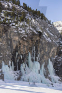 Skiers underneath the frozen waterfall, Hidden valley ski area, Lagazuoi,Armentarola 101, Ski piste,  Dolomites, UNESCO world heritage site Dolomites, South Tyrol, Italy.