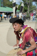Naga tribal man in traditional outfit playing drum, Kisima Nagaland Hornbill festival, Kohima, Nagaland, India