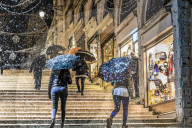 People on Rialto Bridge with umbrellas during rare snowfall, Winter evening, Venice, UNESCO World Heritage Site, Veneto, Italy
