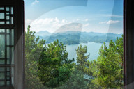 A view out the window on pine trees, the lake and mountain chains of Zhejiang province, China, Asia