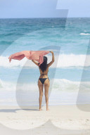 Young Brazilian woman 20-29 years with a beach shawl blowing in the wind