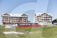 Red wagons of Wengernalpbahn rack railway run next to alpine hotels, Wengen, Bernese Oberland, Canton of Bern, Switzerland, Europe