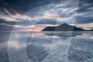 Midnight sun and clouds reflected in the clear water of sea Skagsanden, Flakstad, Nordland county, Lofoten Islands, Norway, Scandinavia, Europe