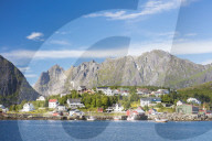 The blue sea frames the fishing village and the rocky peaks, Reine, Moskenesoya, Lofoten Islands, Norway, Scandinavia, Europe