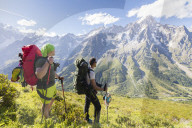 Hikers on steep path admire the rocky peaks of Mont De La Saxe Courmayeur Aosta Valley Italy Europe