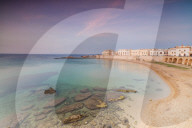 Turquoise sea frames the beach and the medieval old town at sunset Gallipoli province of Lecce Apulia Italy Europe