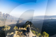 Woman enjoying the early morning sun on the cliffs, world heritage sight, Simien mountains national park, Debarq, Ethiopia