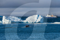 Zodiac cruising back to a cruise ship anchoring behind an iceberg, Brown Bluff, Antarctica, Polar Regions