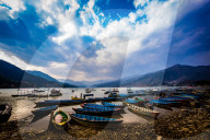 Boats docked on a lake at sunset in Pokhara, Nepal