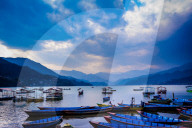 Boats docked on a lake at sunset in Pokhara, Nepal
