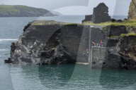Coasteering activity with people jumping from the former quarry building at the Abereiddy blue lagoon, Pembrokeshire.