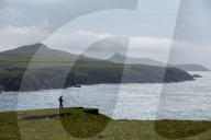 A walker enjoying a moments rest to admire the stunning views from the cliffs along the Pembrokeshire coast path.