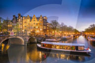 Canal scene with tour boat at dusk, Amsterdam, Netherlands