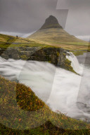 Kirkjufellsfoss in Autumn with hiker to show scale, Iceland.