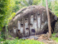 Where there aren't cliffs or caves, crypts are carved into boulders. Tana Toraja, Sulawesi, Indonesia, Asia