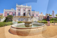 A tourist takes a photo at the entrance of Estoi Palace, in the Algarve, Portugal.